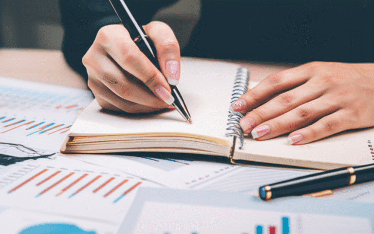 Planejamento Financeiro Nômade Mão escrevendo em um caderno com gráficos financeiros
