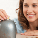 Mulher sorrindo depositando moedas em um cofre